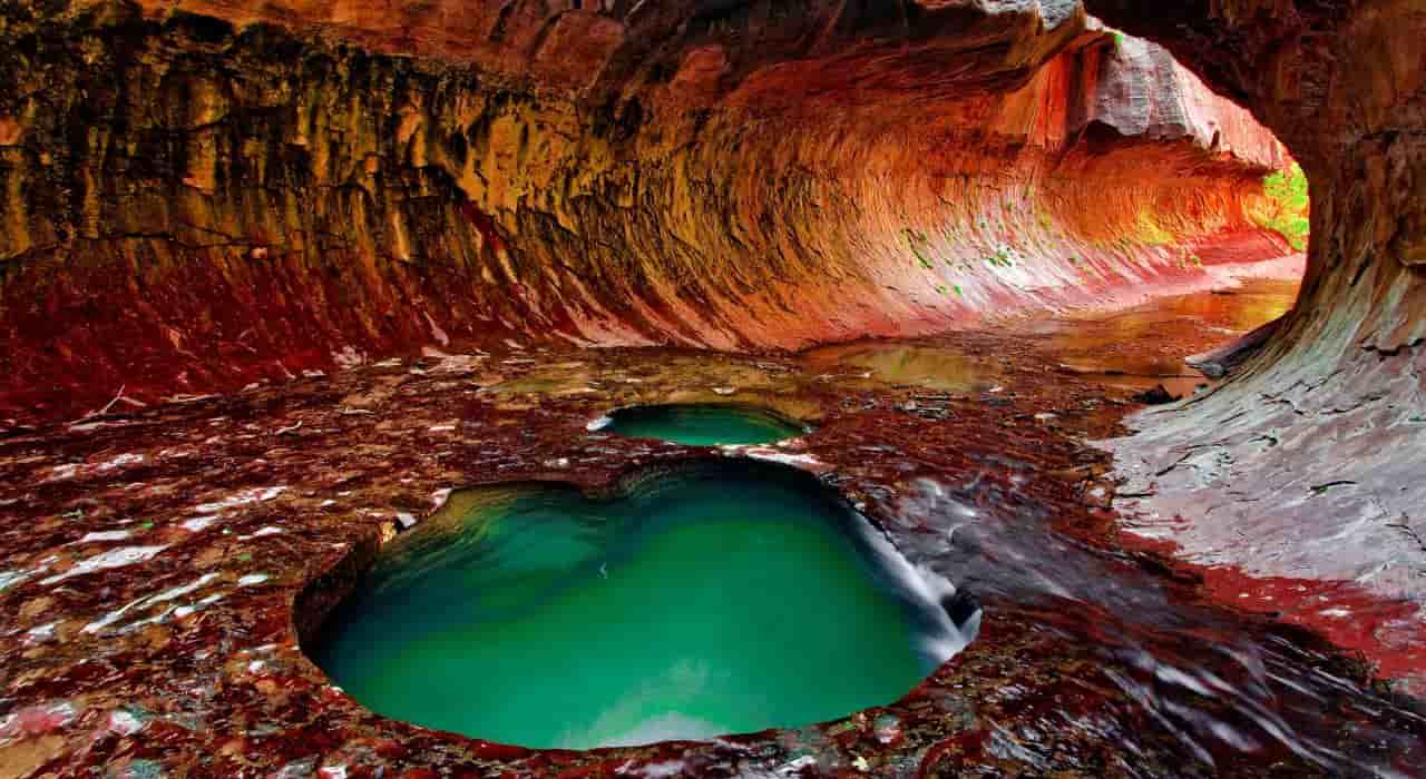 A wide view from inside a slot canyon with small bodies of water near St George Utah